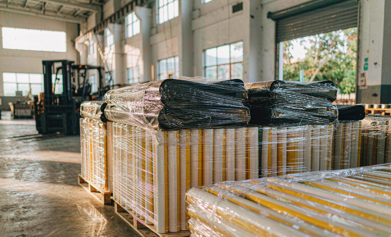 Pallets of rolled PVC strip curtains and rubber mats wrapped for export